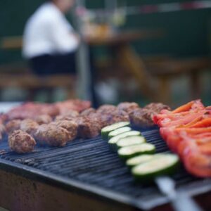 Image of skewers of tomatoes, zuccini, and beef on a grill.