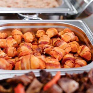 Image of bacon-wrapped scallops in a metal hot tray.